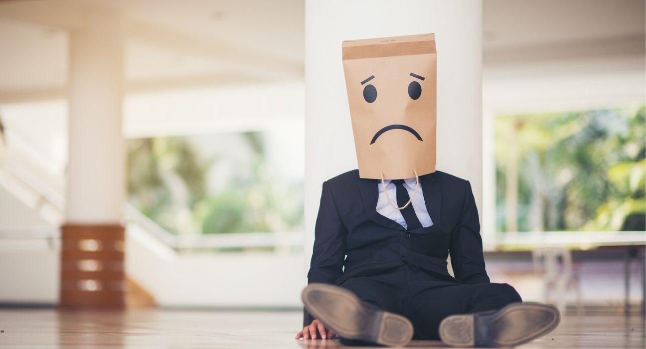 Symbolic image showing a person sitting with bowed head representing learned helplessness